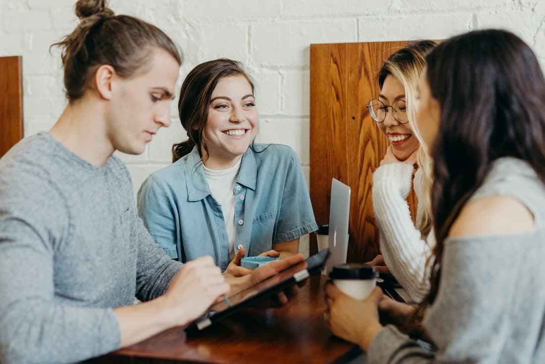Four people planning around a cafe table